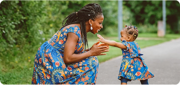 Baby playfully reaching her hand out to her mum