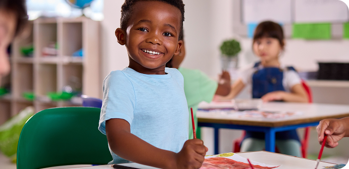 Little boy painting at school