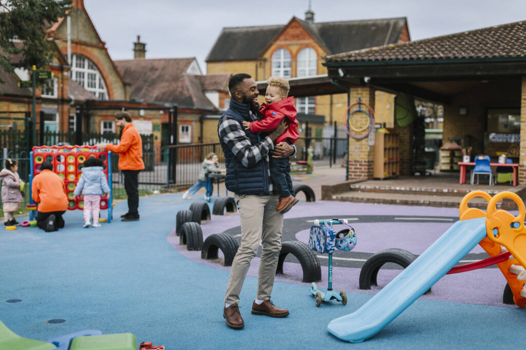 Father figure picking up child from school based nursery
