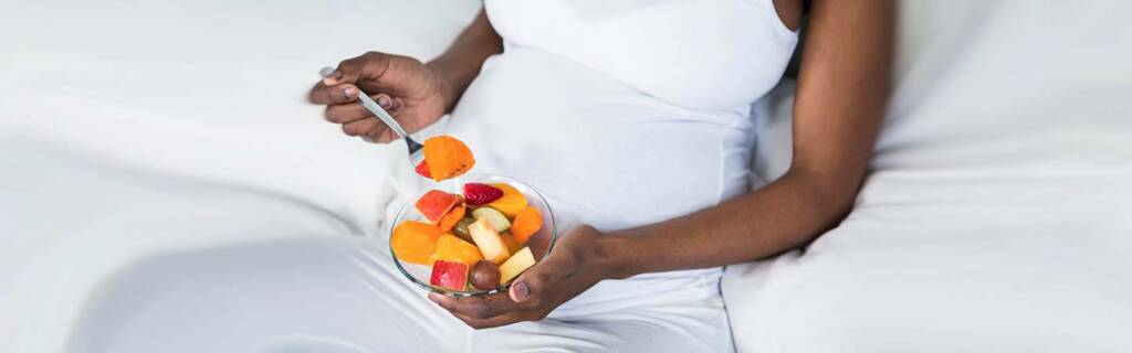Pregnant lady eating fruit