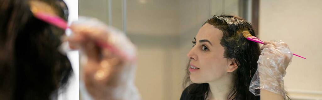 Lady dying hair in mirror