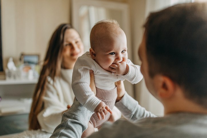 Parents playing with their baby at home