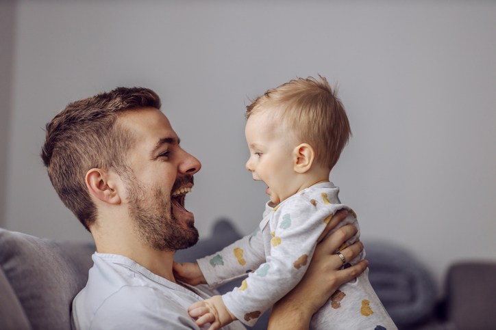 Father smiling and playing with his baby