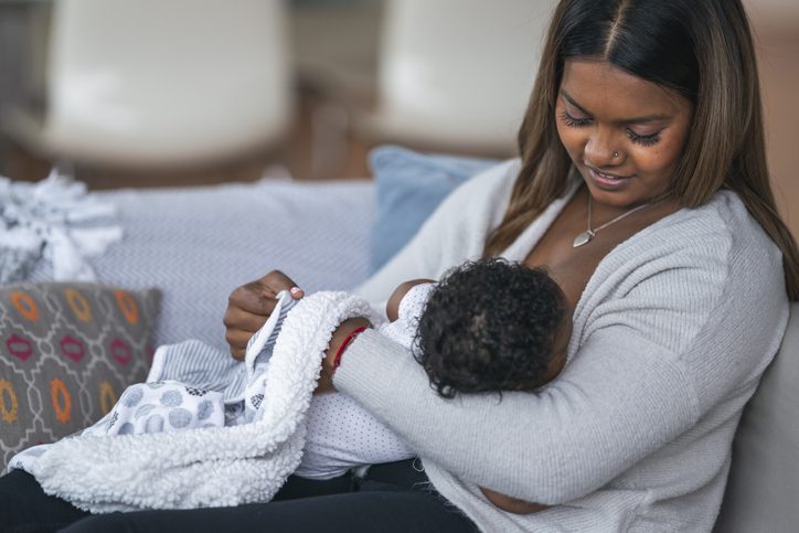 Mother breastfeeding her baby at home