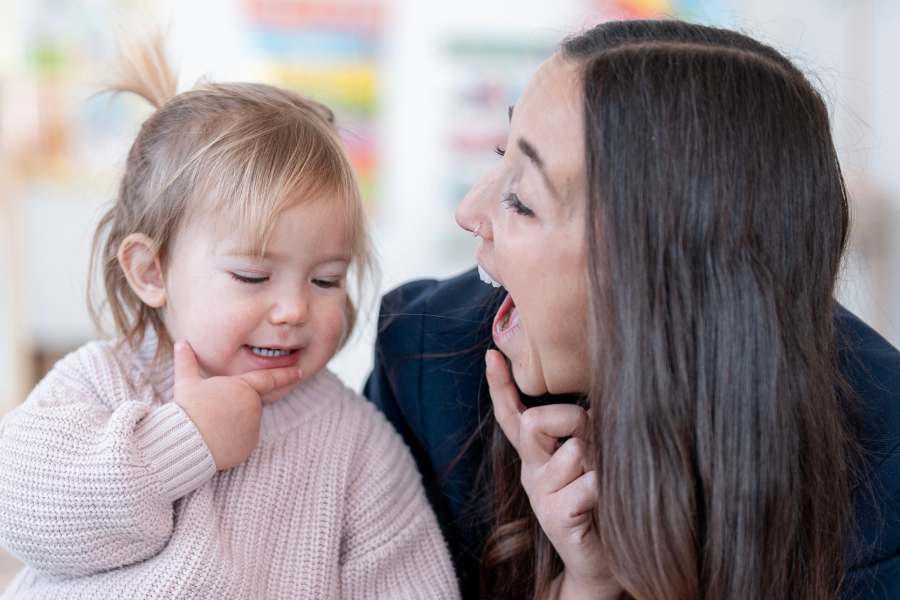 Mother encouraging a young child during a learning activity