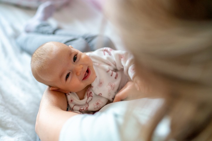 Smiling baby looking up at their parent